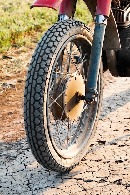 写真 汚れた道路の古い車輪のオートバイ