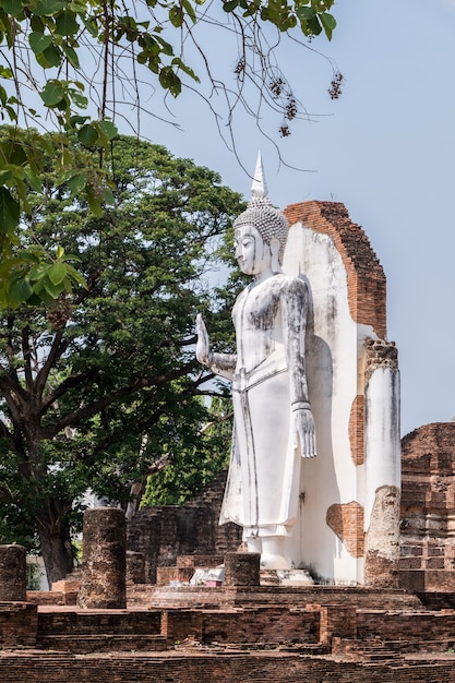 Старая белая статуя Будды стоит в древней церкви.