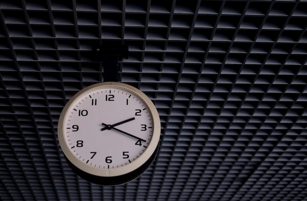 Old white Circle clock hanging under ceiling.