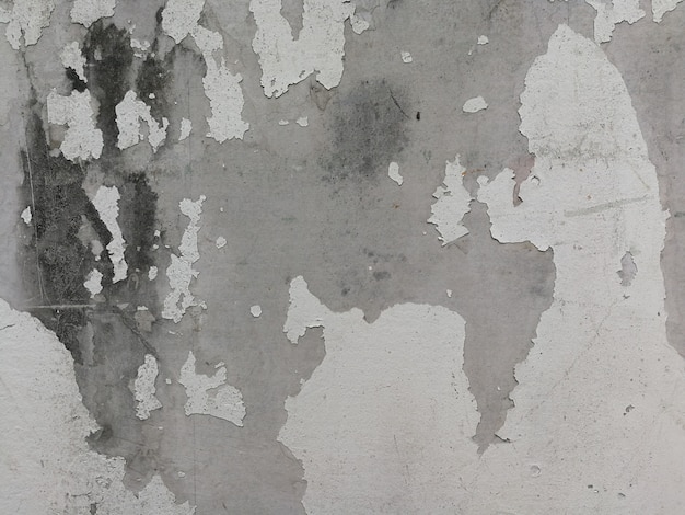 Old white concrete wall with paint cracks. Background texture