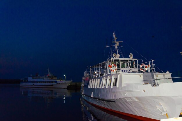 Foto una vecchia nave bianca nel porto vicino al molo.