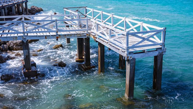 Old white wooden bridge walkway over sea beach, Sang Wan beach Koh Larn, Pattaya, Thailand