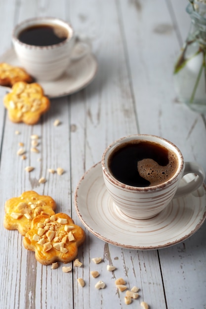 Su un vecchio tavolo di legno bianco una tazza di caffè aromatico.