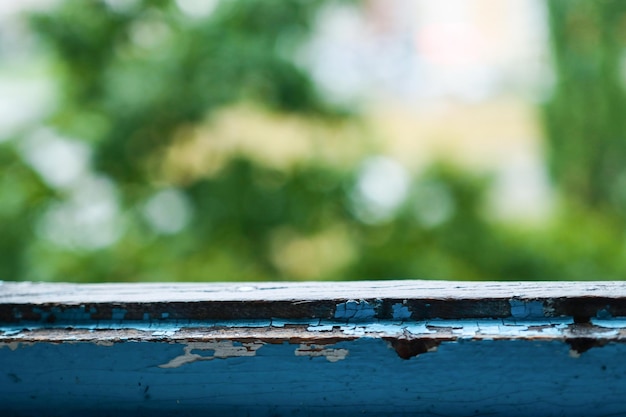 Old window frame blue color closeup front view rainy autumn weather blurred forest background