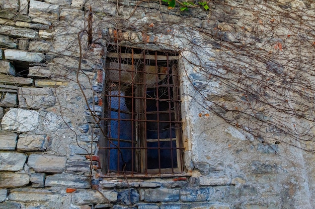 Una vecchia finestra in una casa di pietra su una strada a varenna, una piccola cittadina sul lago di como, italy