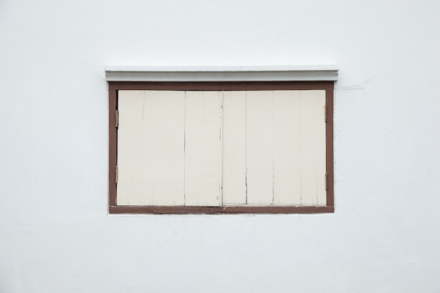 흰 벽에 오래 된 창입니다.