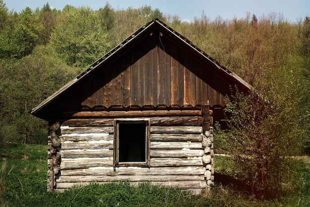 Old window and wooden cottage aged cottage traveling in sunny mountains