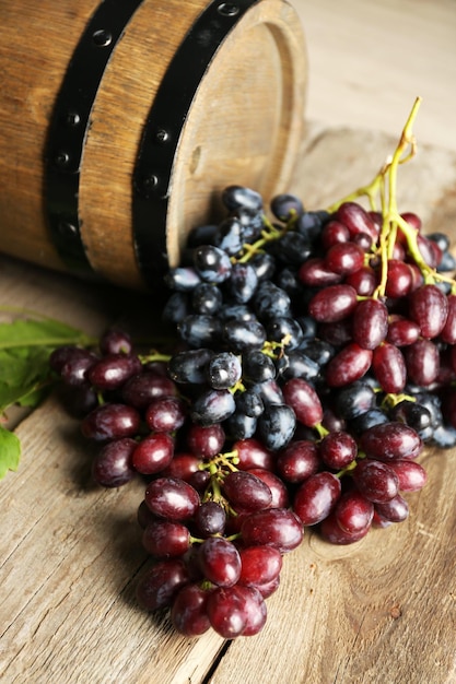 Old wine barrel and grape on wooden background