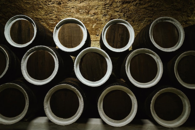 Photo old wine oak barrels in a wine cellar stored in a winery