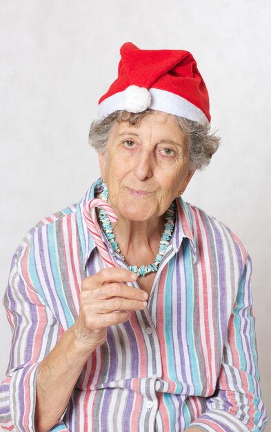 Old woman between 70 and 80 years old in the hat of a santa claus