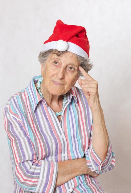 Old woman between 70 and 80 years old in the hat of a santa claus