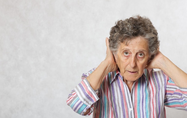 Old woman between 70 and 80 years old shows that she takes care of her hair