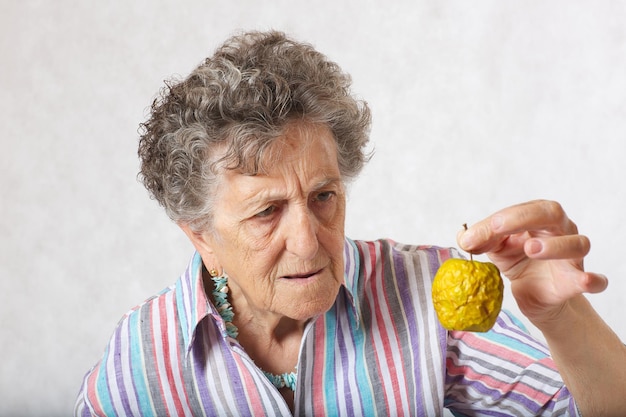 Old woman between 70 and 80 years old and shrivelled apple