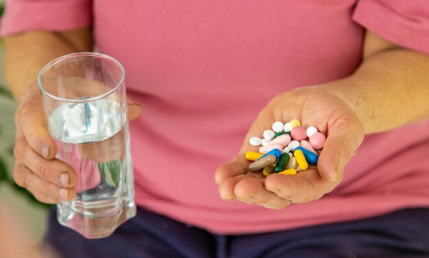 An old woman holds pills in her hands Selective focus Peopel