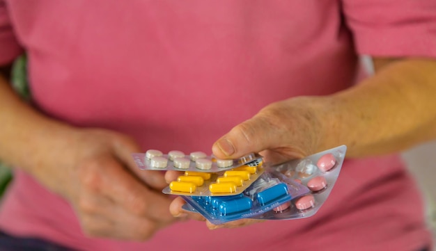 An old woman holds pills in her hands Selective focus Peopel