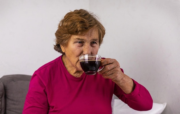 An old woman is drinking coffee Selective focus