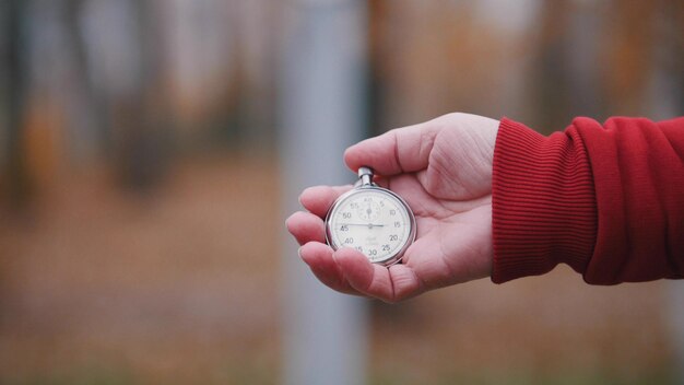 An old woman is holding a pocket watch