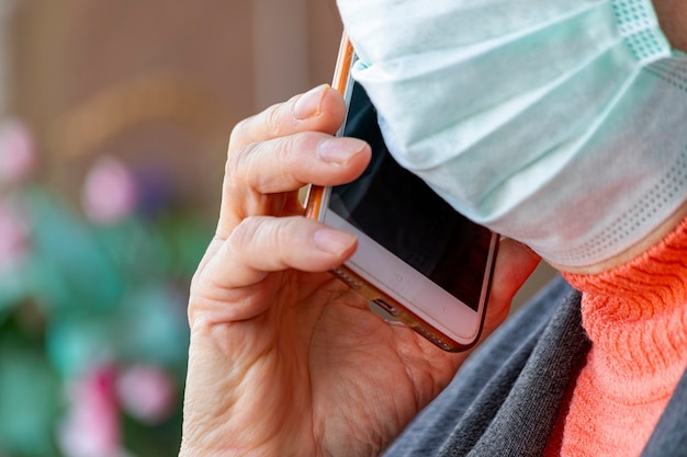 Old woman is wearing mask and calling by mobile phone