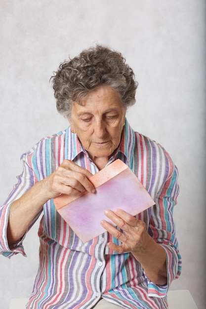 Old woman keeps a letter in her hands