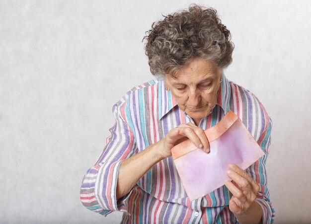 Old woman keeps a letter in her hands