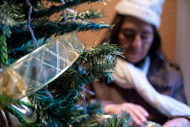 Photo old woman laces the christmas tree