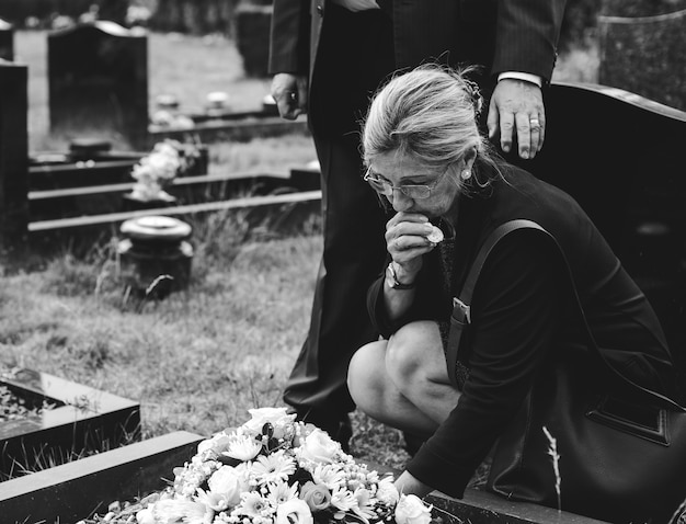 歳の女性が墓に花を敷設