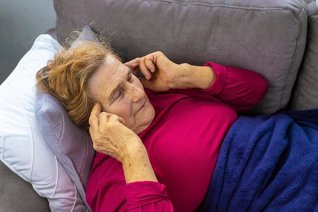 An old woman lies with a headache Selective focus