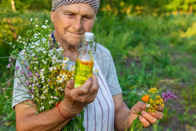 Old woman makes herbal tincture Selective focus