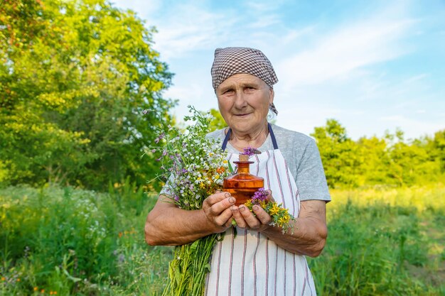 Old woman makes herbal tincture Selective focus