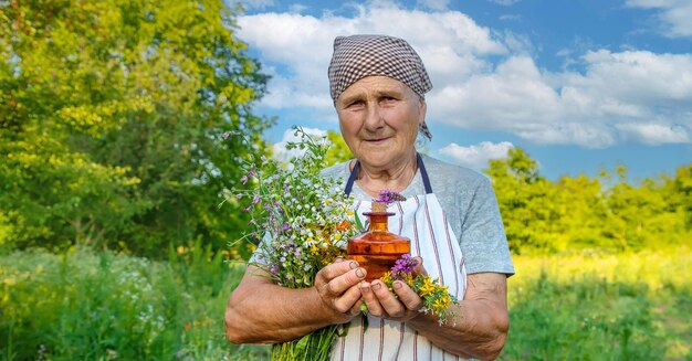 Old woman makes herbal tincture Selective focus