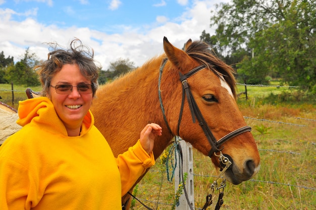 Vecchia donna in posa con il suo cavallo