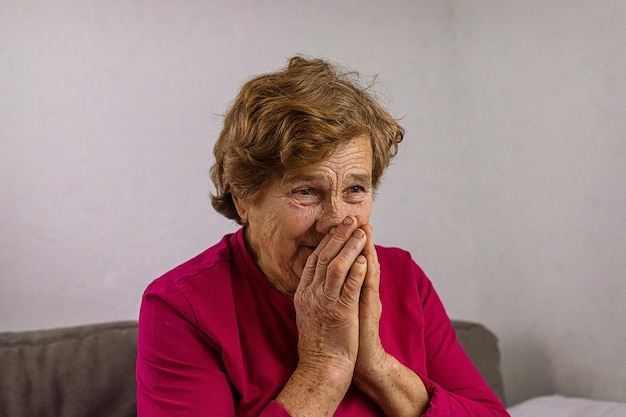 An old woman prays at home Selective focus