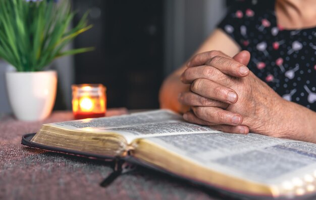 An old woman reads the bible hands close up