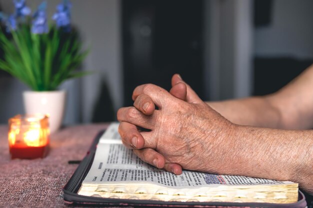 An old woman reads the bible hands close up