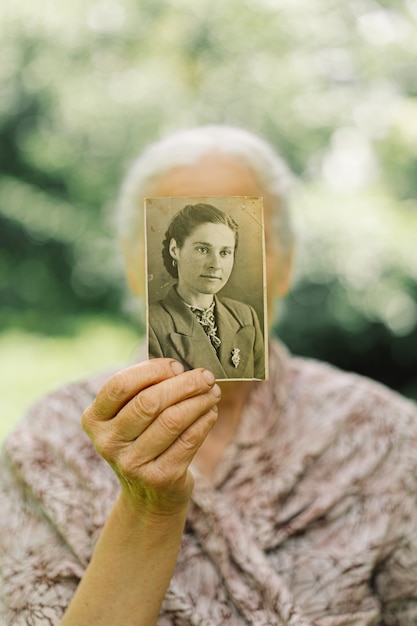 Photo old woman remembers her youth. grandma keeps her photo in her youth. memories. vintage old photos