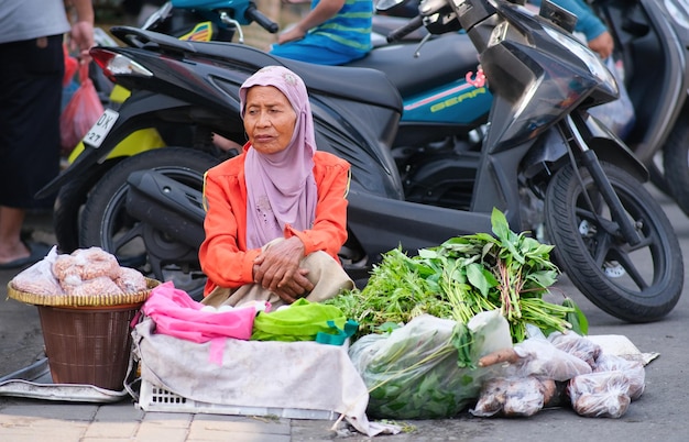 Old woman selling vegetables in local wet market of Yogyakarta 25 January 2024