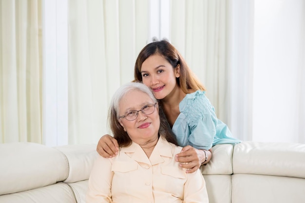 Old woman smiles at the camera with her daughter