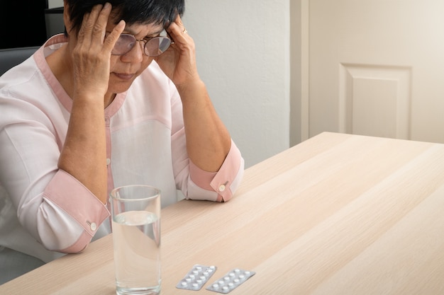 頭痛、ストレス、片頭痛、健康問題の概念に苦しんでいる老婦人