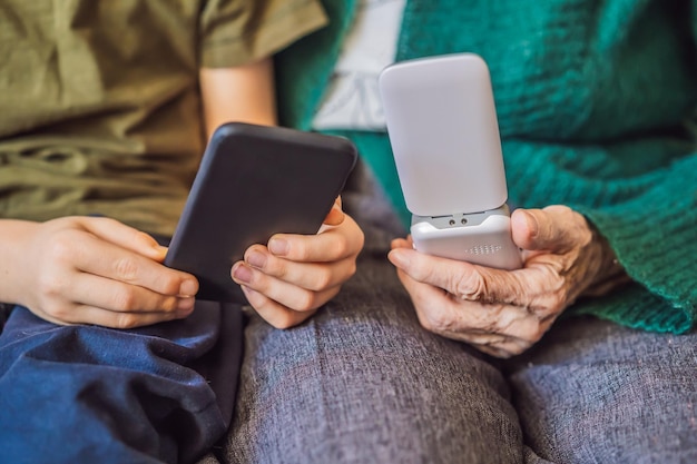 Old woman uses an old phone boy uses a smartphone