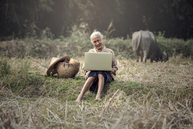 Old woman using a laptop outdoor