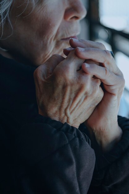 Vecchia donna che si scalda in una fredda giornata invernale