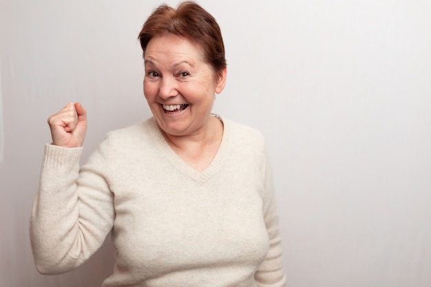 Old woman on white in a light sweater