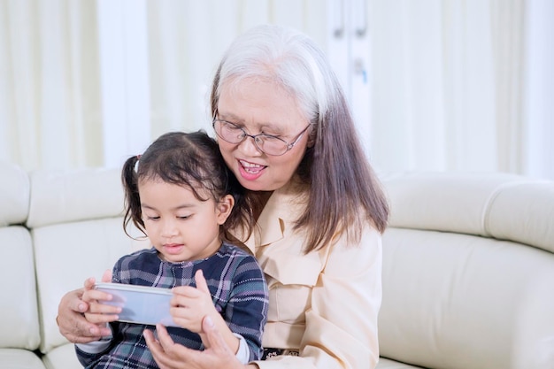 Old woman with her grandchild using a mobile phone