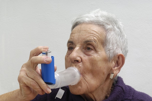 Old woman with an inhaler