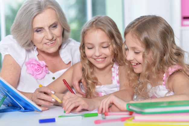 Old woman with tweenie   girls doing homework  at home