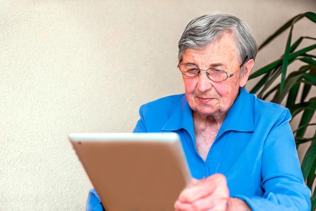 old woman works on a tablet. video communication