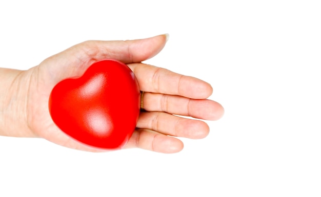 The old womans hand holding a red heart in donate help give love warmth take care. World Health Day.