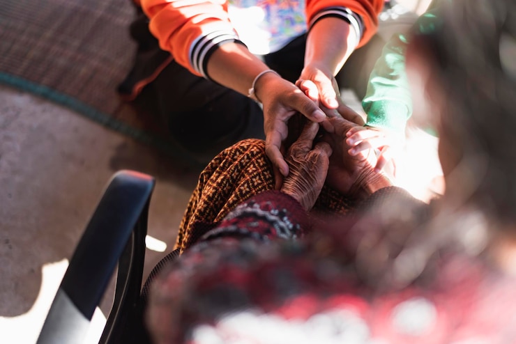 Photo old womans hand holding a young womans hand helping caring for the elderly concept