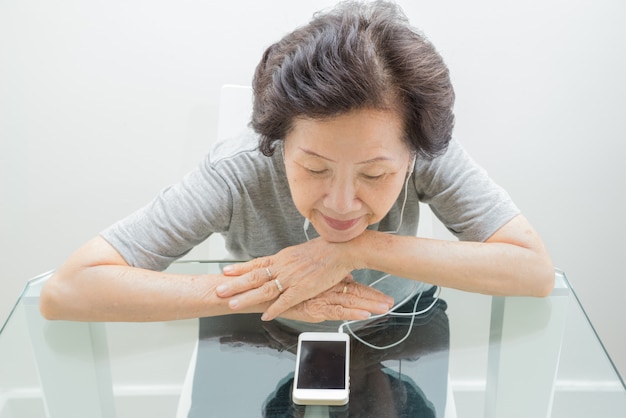 Old women  listening to music from mobile