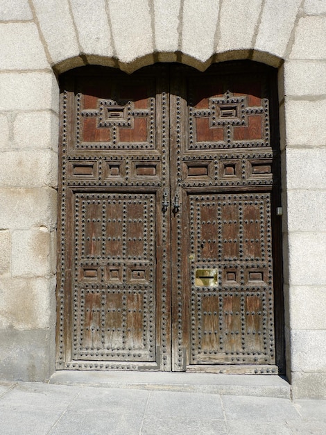 Старая деревянная старинная дверь в Мадриде, Испания. Потрепанный винтажный исторический вход возле мэрии.